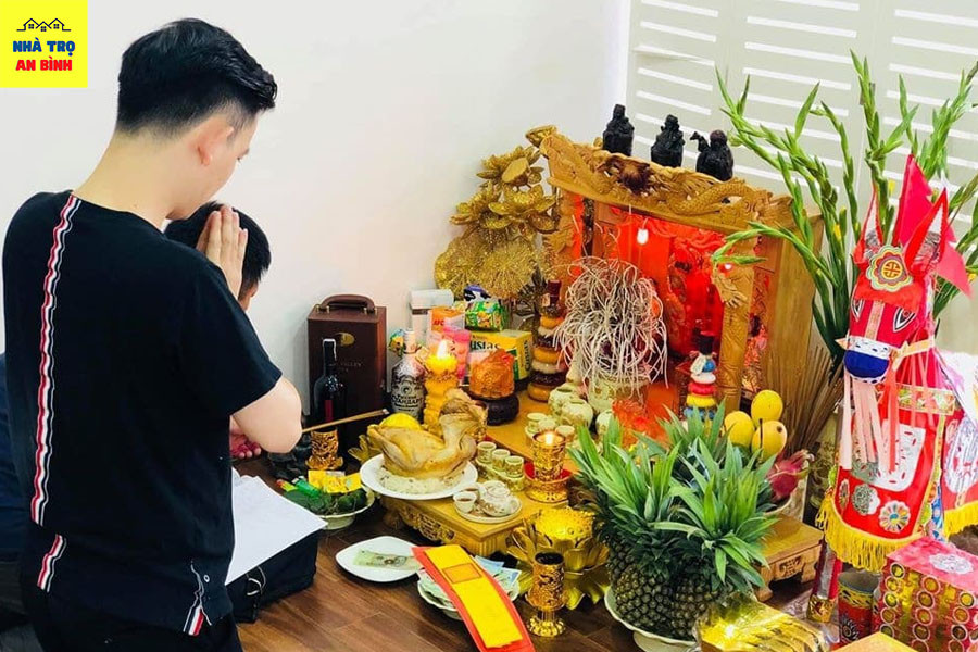 Lễ vật được bày biện trên bàn thờ tạm bợ trong phòng trọ, thể hiện sự thành kính của gia chủ