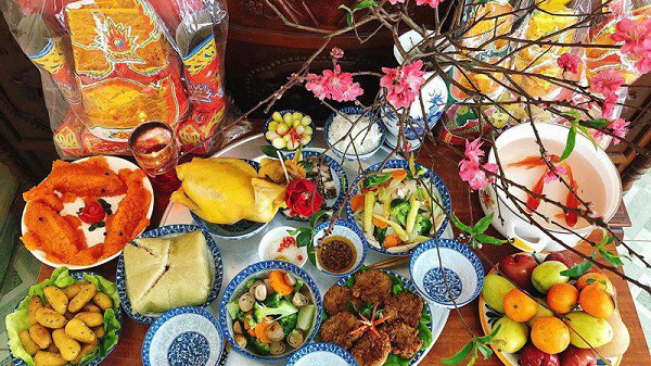 Mâm cúng gia tiên đầy đủ lễ vật với xôi, gà, hoa quả và bánh chưng, chuẩn bị cho ngày 25 tháng Chạp