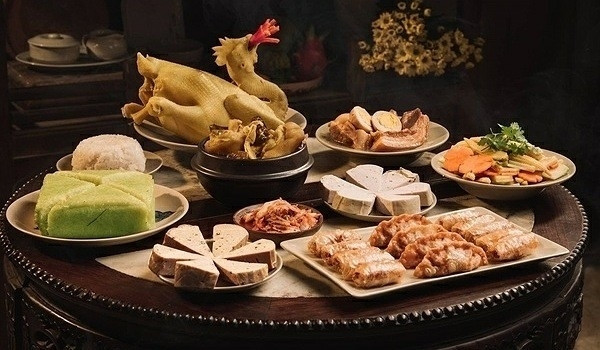 Mâm lễ vật cúng ngoài trời với hương hoa, trái cây, và nến trong ngày Thanh Minh.