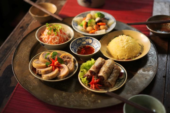 Người phụ nữ đang cúng Rằm tháng 7 tại ban thờ gia tiên