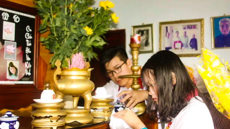 Người phụ nữ tỉ mỉ lau dọn bàn thờ đón Tết, thể hiện sự thành kính trong nghi thức tỉa chân nhang