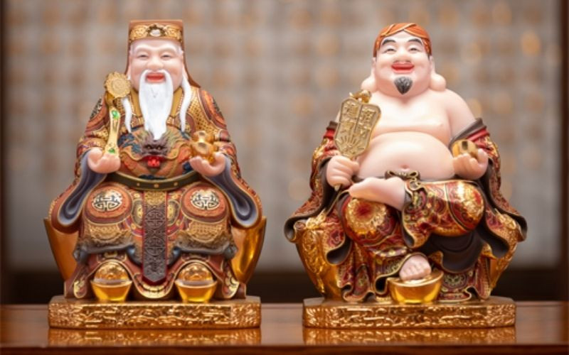 Tượng Ông Địa và Thần Tài trên bàn thờ gỗ
