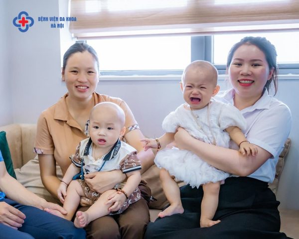 Em bé sơ sinh cười rạng rỡ trên tay mẹ, tượng trưng cho niềm hạnh phúc khi đón con yêu