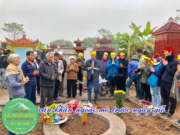 Một gia đình đang làm lễ cúng cáo tại mộ phần tổ tiên, thể hiện lòng hiếu kính trước ngày giỗ.