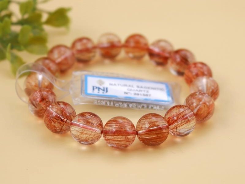 Vòng tay thạch anh tóc đỏ đeo trên cổ tay, biểu tượng cho may mắn tình duyên và bình an