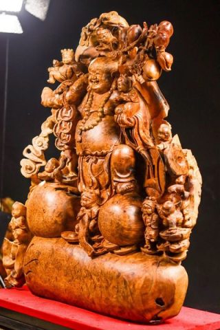 Di Lặc cửu tiểu vác đào gỗ nu hương.